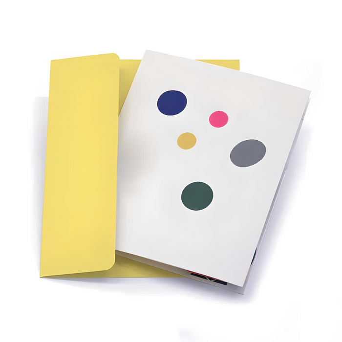 Minimalist greeting card with colorful abstract dots on a white cover, paired with a soft yellow envelope in a clean modern stationery presentation.
