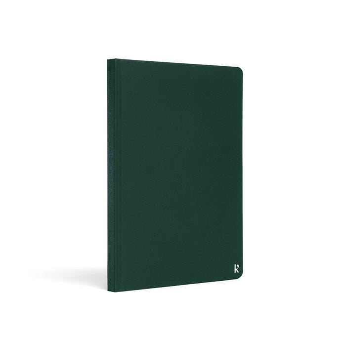 Karst A5 hardcover stone paper notebook in forest green with rounded corners and subtle logo detail, standing upright on a light gray background.
