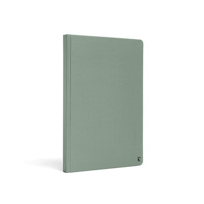 Karst A5 hardcover stone paper notebook in eucalyptus green with rounded corners and subtle logo detail, standing upright on a light gray background.