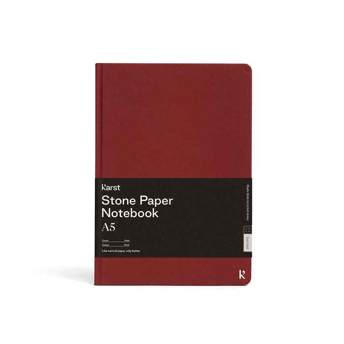 Karst Stone Paper Notebook A5 in pinot red with a hard cover, featuring a minimalist design and branded wrap on a white background.