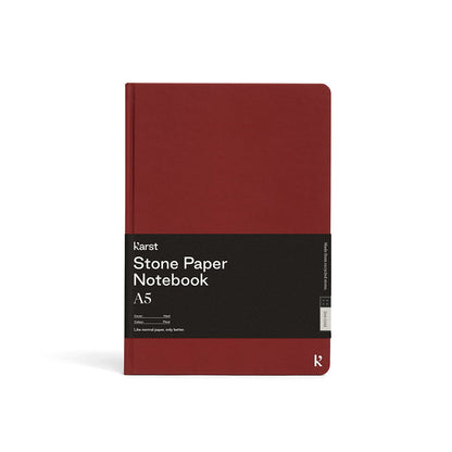 Karst Stone Paper Notebook A5 in pinot red with a hard cover, featuring a minimalist design and branded wrap on a white background.