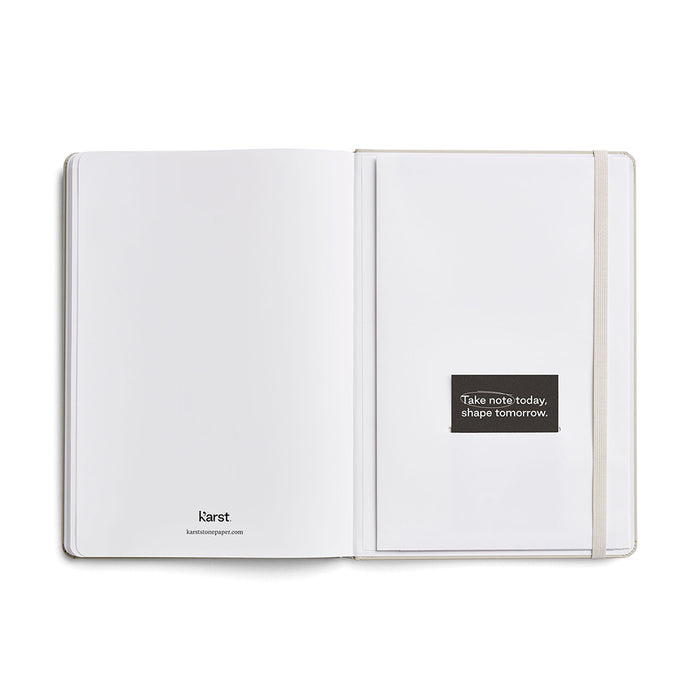 Inside back pages of a Karst A5 stone paper notebook, shown open with a blank page, elastic closure band, and a branded message card reading ‘Take note today, shape tomorrow’ on a white background.