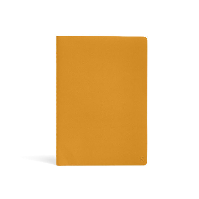 Karst Stone Paper Notebook A5 in turmeric yellow, featuring a minimalist soft-touch cover with rounded corners on a white background.