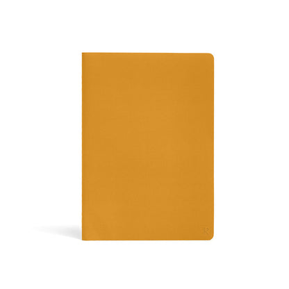 Karst Stone Paper Notebook A5 in turmeric yellow, featuring a minimalist soft-touch cover with rounded corners on a white background.
