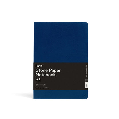 Karst Stone Paper Notebook A5 with a navy blue soft cover and black belly band label, shown front-facing on a white background.