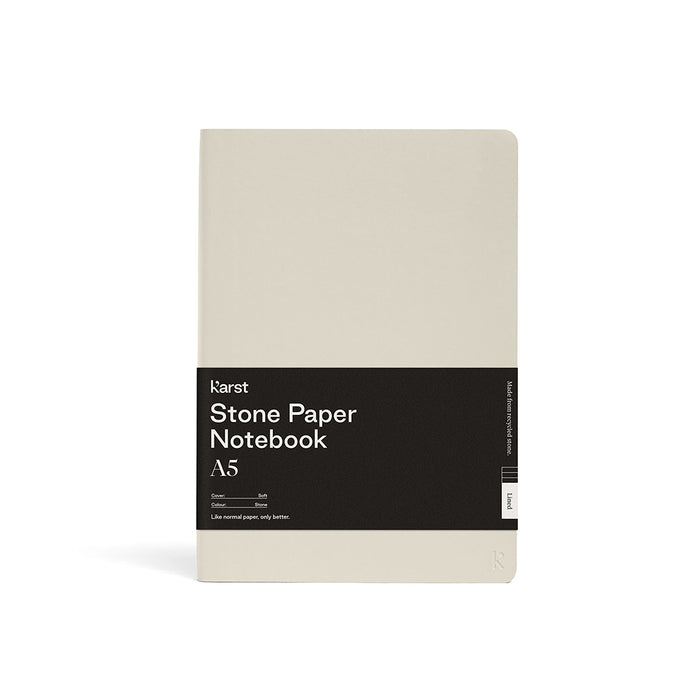 Karst Stone Paper Notebook A5 with a soft cream cover and rounded corners, wrapped in a black product band, photographed front-facing on a white background.