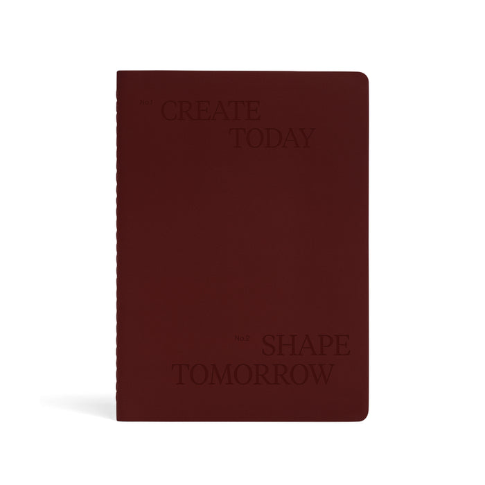 Karst Stone Paper Undated Planner in burgundy with embossed “Create Today, Shape Tomorrow” text on minimalist hardcover notebook.