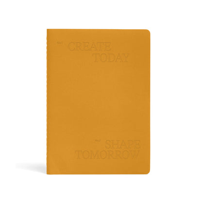 Karst Stone Paper Undated Planner in turmeric yellow with embossed “Create Today, Shape Tomorrow” text on minimalist eco-friendly hardcover notebook.