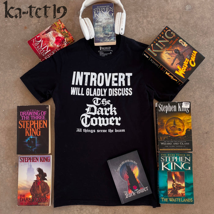 Black t-shirt with 'Introvert will gladly discuss The Dark Tower' text, surrounded by Stephen King books on a concrete surface.