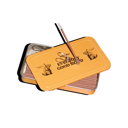 Open yellow Collins Everyday Good Mood incense tin with pink incense sticks and metal clip holder, compact minimalist home fragrance set styled on a clean white background.