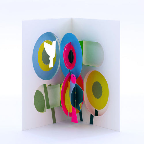 Open 3D pop-up greeting card featuring colorful abstract flowers and birds in bright blue, pink, yellow, green, and white, displayed in a bold modern paper art design.