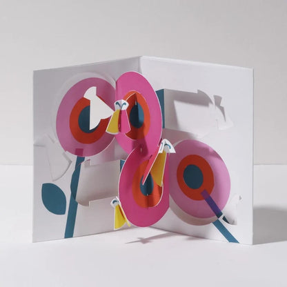 Open 3D pop-up greeting card featuring bright pink flowers with colorful butterflies in a bold modern paper art design, perfect for birthdays, spring celebrations, and special occasions.