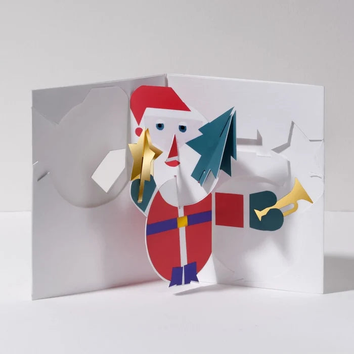 Open 3D pop-up Christmas card featuring Santa Claus holding a gold star and green tree, with a trumpet and gift bag in a festive modern paper art design.