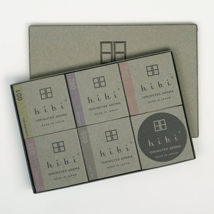 Open Hibi large gray gift box on a white background, displaying six neatly arranged incense matchbook boxes in assorted scents, with the gray Hibi box lid placed behind.