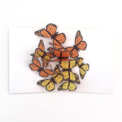 Open 3D pop-up greeting card featuring a vibrant cluster of orange and yellow monarch butterflies on a white background, elegant paper art card for birthdays, celebrations, and nature lovers.