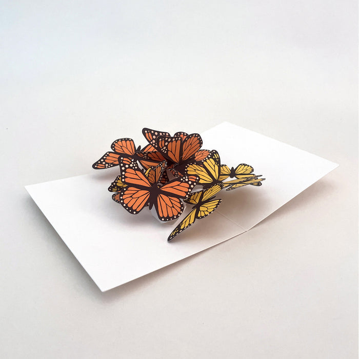 Open 3D pop-up greeting card featuring a cluster of orange and yellow monarch butterflies on a white card base, elegant paper art card for birthdays, celebrations, and nature lovers.