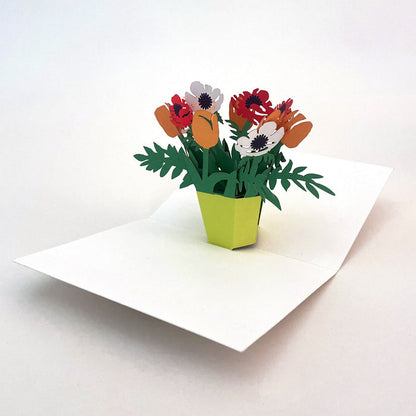 Open 3D pop-up greeting card featuring a vibrant bouquet of orange, red, and white paper flowers in a bright green vase, elegant floral paper art card for birthdays, thank you notes, and special occasions.