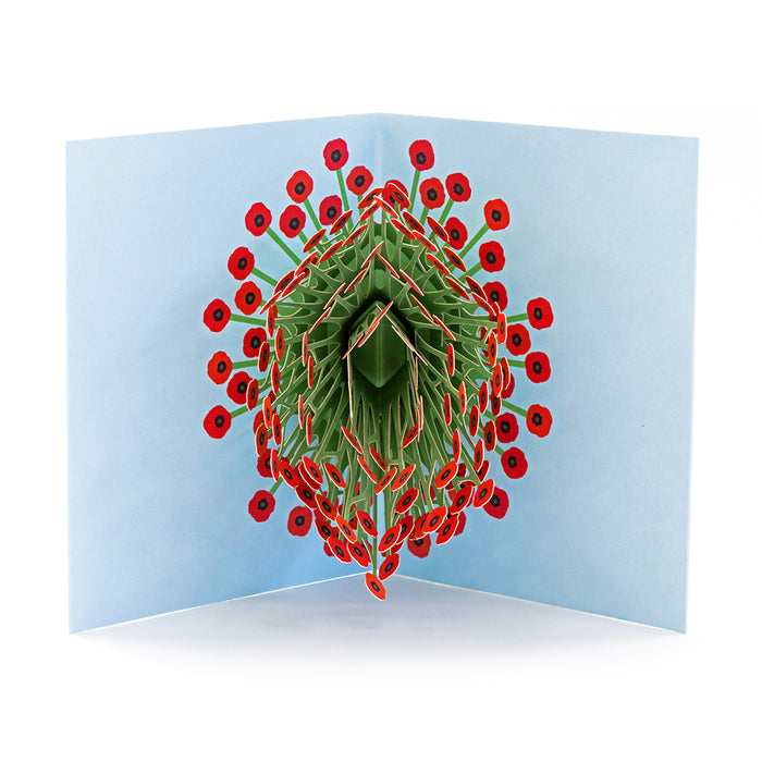 Open 3D pop-up greeting card featuring a sculptural bouquet of red poppy flowers with intricate green paper stems on a pale blue background, elegant floral paper art for special occasions.