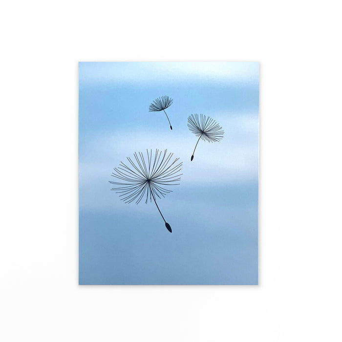 Greeting card with minimalist dandelion seed illustrations drifting across a soft blue sky background, elegant botanical stationery for nature lovers and special occasions.