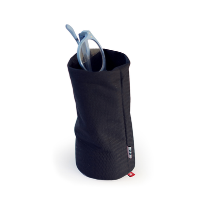 Minimalist black soft fabric desk organizer used as an eyeglass holder, modern multifunctional container for glasses, pens, or small office accessories.