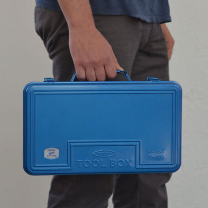 Blue Toyo steel toolbox T-360 held by a person using the top handle.