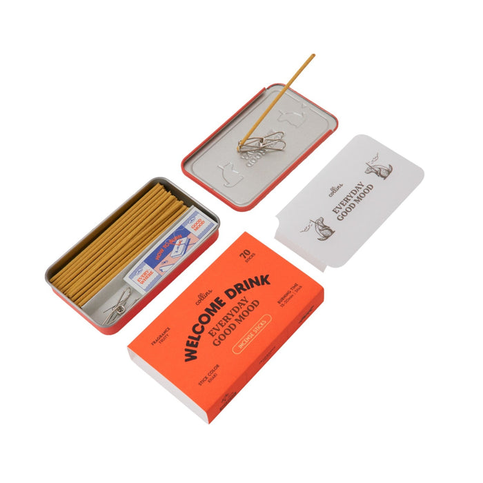 Collins Everyday Good Mood incense set labeled “Welcome Drink,” shown open with incense sticks, metal clip holder, tray lid, and bright orange packaging on a clean white background.
