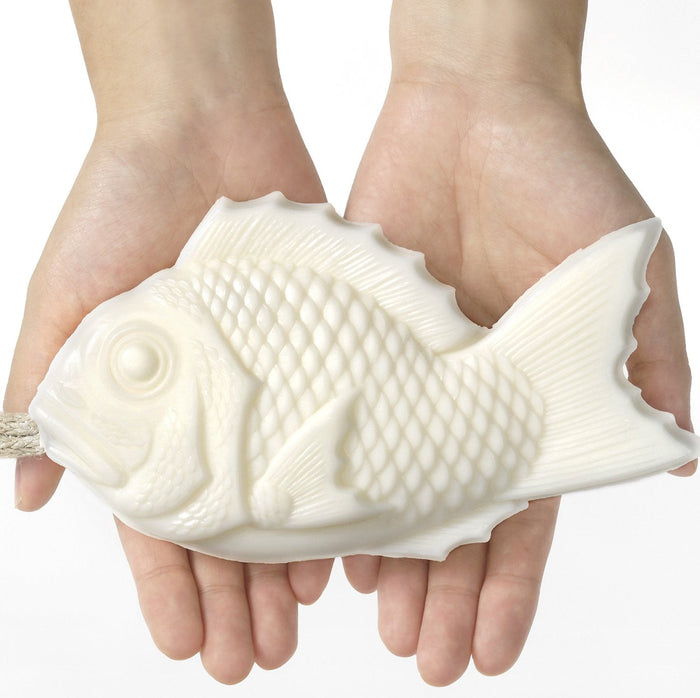 White Tamanohada fish-shaped welcome soap held in hands, large decorative Japanese bath soap inspired by traditional tai fish design.